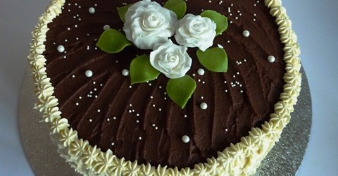 Honey sponge cake with fresh whipped cream. Sugar paste roses, chocolate and fresh whipped cream decorations.